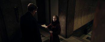 Movie still from “Mr. Jones” (2019), directed by Agnieszka Holland – A woman in a red coat and a man in a black robe; Medium shot, Over the shoulder angle