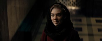 Movie still from “Mr. Jones” (2019), directed by Agnieszka Holland – A woman wearing a black scarf and a red dress; Close Up shot, Over the shoulder angle