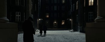 Movie still from “Mr. Jones” (2019), directed by Agnieszka Holland – Two people are standing in the snow in front of a building; Extreme Wide shot, High angle