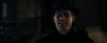Movie still from “Mr. Jones” (2019), directed by Agnieszka Holland – A man wearing a hat and glasses smiling; Close Up shot, Low angle