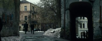 Movie still from “Mr. Jones” (2019), directed by Agnieszka Holland – A person walking down a street near a building; Extreme Wide shot, High angle