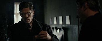 Movie still from “Mr. Jones” (2019), directed by Agnieszka Holland – A man wearing glasses and a black jacket; Close Up shot, Over the shoulder angle