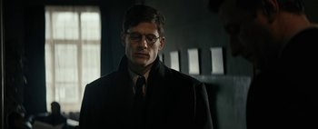 Movie still from “Mr. Jones” (2019), directed by Agnieszka Holland – A man in a black coat and glasses; Close Up shot, Over the shoulder angle