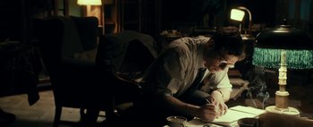 Movie still from “Mr. Jones” (2019), directed by Agnieszka Holland – A man sitting at a table writing on a piece of paper; Medium shot, Over the shoulder angle