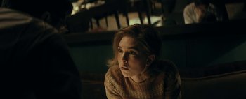 Movie still from “Mr. Jones” (2019), directed by Agnieszka Holland – A woman sitting in front of a wooden table; Close Up shot, Over the shoulder angle