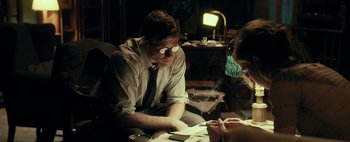 Movie still from “Mr. Jones” (2019), directed by Agnieszka Holland – A man sitting at a table looking at papers; Medium shot, Over the shoulder angle