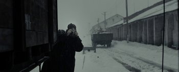 Movie still from “Mr. Jones” (2019), directed by Agnieszka Holland – A man taking a picture in the snow with a camera; Medium shot, Over the shoulder angle