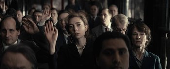 Movie still from “Mr. Jones” (2019), directed by Agnieszka Holland – A group of people standing in a room; Medium shot, Low angle