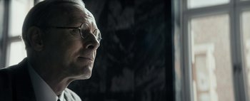 Movie still from “Mr. Jones” (2019), directed by Agnieszka Holland – An older man wearing glasses looking off into the distance; Close Up shot, Over the shoulder angle