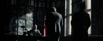 Movie still from “Mr. Jones” (2019), directed by Agnieszka Holland – A man standing in front of another man in front of a window; Wide shot, Over the shoulder angle