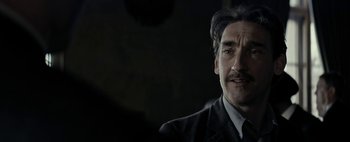 Movie still from “Mr. Jones” (2019), directed by Agnieszka Holland – A person wearing a suit and tie; Close Up shot, Over the shoulder angle