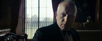 Movie still from “Mr. Jones” (2019), directed by Agnieszka Holland – An older man wearing a suit and bow tie in front of a window; Close Up shot, Low angle
