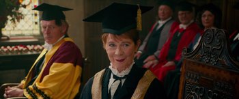 Movie still from “Mamma Mia! Here We Go Again” (2018), directed by Ol Parker – An older woman wearing a graduation cap and gown; Medium shot, Over the shoulder angle