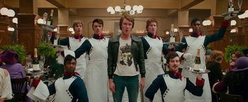 Movie still from “Mamma Mia! Here We Go Again” (2018), directed by Ol Parker – A group of men standing next to each other in front of a chandelier; Medium shot, Low angle