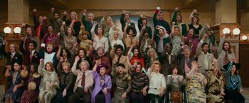 Movie still from “Mamma Mia! Here We Go Again” (2018), directed by Ol Parker – A large group of people wearing costumes and hats; Wide shot, High angle