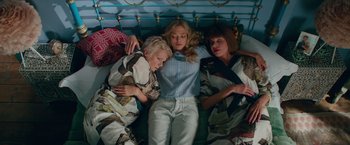 Movie still from “Mamma Mia! Here We Go Again” (2018), directed by Ol Parker – A group of people laying in a bed together; Medium shot, Overhead angle