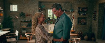 Movie still from “Mamma Mia! Here We Go Again” (2018), directed by Ol Parker – A man and a woman standing next to each other in a kitchen; Medium shot, Over the shoulder angle
