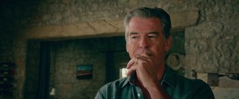 Movie still from “Mamma Mia! Here We Go Again” (2018), directed by Ol Parker – A person with a hand on his chin; Close Up shot, Over the shoulder angle