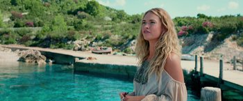 Movie still from “Mamma Mia! Here We Go Again” (2018), directed by Ol Parker – A beautiful blond haired woman standing in front of a body of water; Medium shot, Low angle