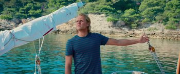Movie still from “Mamma Mia! Here We Go Again” (2018), directed by Ol Parker – A man standing in the water holding onto a boat; Medium shot, Over the shoulder angle