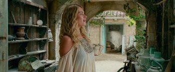 Movie still from “Mamma Mia! Here We Go Again” (2018), directed by Ol Parker – A beautiful young woman standing next to a building; Medium shot, Over the shoulder angle