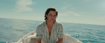 Movie still from “Mamma Mia! Here We Go Again” (2018), directed by Ol Parker – A man sitting on a boat in the water; Medium shot, High angle