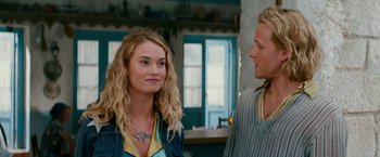 Movie still from “Mamma Mia! Here We Go Again” (2018), directed by Ol Parker – A man and a woman standing next to each other in a room; Close Up shot, Over the shoulder angle