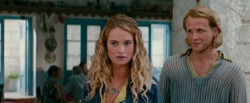 Movie still from “Mamma Mia! Here We Go Again” (2018), directed by Ol Parker – A woman with long blonde hair wearing a necklace; Close Up shot, Over the shoulder angle