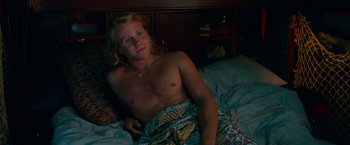 Movie still from “Mamma Mia! Here We Go Again” (2018), directed by Ol Parker – A man laying on a bed with a blanket around him; Medium shot, High angle