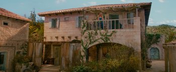 Movie still from “Mamma Mia! Here We Go Again” (2018), directed by Ol Parker – An old building with vines growing all over it; Extreme Wide shot, Low angle