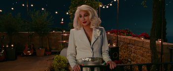 Movie still from “Mamma Mia! Here We Go Again” (2018), directed by Ol Parker – A woman with blonde hair wearing a white suit; Medium shot, Over the shoulder angle