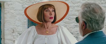 Movie still from “Mamma Mia! Here We Go Again” (2018), directed by Ol Parker – A woman wearing a hat and a white blouse; Close Up shot, Over the shoulder angle