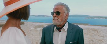 Movie still from “Mamma Mia! Here We Go Again” (2018), directed by Ol Parker – An older man wearing a suit and sunglasses; Close Up shot, Low angle
