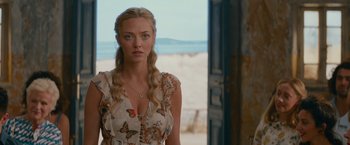 Movie still from “Mamma Mia! Here We Go Again” (2018), directed by Ol Parker – A woman with long blonde hair standing in front of the ocean; Close Up shot, Over the shoulder angle