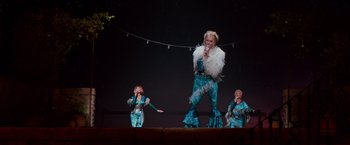 Movie still from “Mamma Mia! Here We Go Again” (2018), directed by Ol Parker – A group of people on a stage singing; Wide shot, High angle