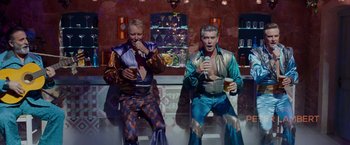 Movie still from “Mamma Mia! Here We Go Again” (2018), directed by Ol Parker – A couple of men sitting next to each other on a bench; Medium shot, Low angle