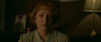 Movie still from “Mrs. Harris Goes to Paris” (2022), directed by Anthony Fabian – An older woman wearing a hat and looking at the camera; Close Up shot, Low angle