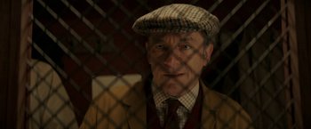 Movie still from “Mrs. Harris Goes to Paris” (2022), directed by Anthony Fabian – An older man wearing a hat and a suit; Close Up shot, Low angle