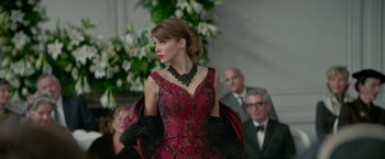 Movie still from “Mrs. Harris Goes to Paris” (2022), directed by Anthony Fabian – A woman in a red and black dress; Medium shot, Over the shoulder angle