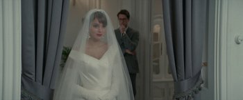Movie still from “Mrs. Harris Goes to Paris” (2022), directed by Anthony Fabian – A woman in a white wedding dress standing next to a man in a suit; Close Up shot, Over the shoulder angle