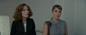 Movie still from “Mrs. Harris Goes to Paris” (2022), directed by Anthony Fabian – Two women sitting next to each other in front of a white wall; Close Up shot, Over the shoulder angle