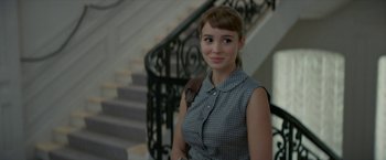 Movie still from “Mrs. Harris Goes to Paris” (2022), directed by Anthony Fabian – A woman standing in front of a railing; Close Up shot, Over the shoulder angle