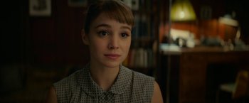 Movie still from “Mrs. Harris Goes to Paris” (2022), directed by Anthony Fabian – A young woman is looking into the camera; Close Up shot, Over the shoulder angle