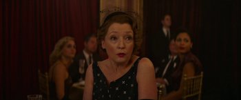Movie still from “Mrs. Harris Goes to Paris” (2022), directed by Anthony Fabian – An older woman wearing a black dress and a black hat; Close Up shot, Over the shoulder angle
