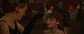 Movie still from “Mrs. Harris Goes to Paris” (2022), directed by Anthony Fabian – A woman getting ready for an event with a makeup artist; Close Up shot, Over the shoulder angle