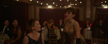 Movie still from “Mrs. Harris Goes to Paris” (2022), directed by Anthony Fabian – Two women are talking to each other at a party; Medium shot, Over the shoulder angle