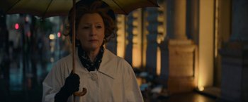 Movie still from “Mrs. Harris Goes to Paris” (2022), directed by Anthony Fabian – An older woman holding an umbrella in the rain; Close Up shot, Low angle