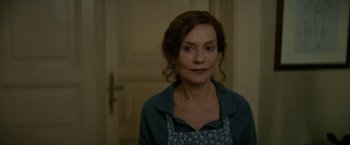 Movie still from “Mrs. Harris Goes to Paris” (2022), directed by Anthony Fabian – A woman in a blue shirt is standing in front of a door; Close Up shot, Over the shoulder angle