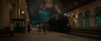 Movie still from “Mrs. Harris Goes to Paris” (2022), directed by Anthony Fabian – People walking in front of a train at a train station; Extreme Wide shot, High angle