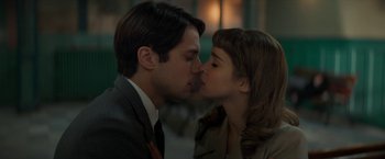 Movie still from “Mrs. Harris Goes to Paris” (2022), directed by Anthony Fabian – A man and a woman kissing each other in front of a building; Close Up shot, Low angle